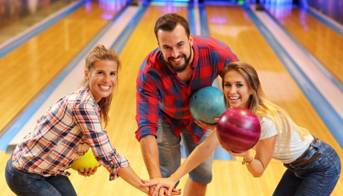 Happy people holding bowling balls